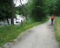 cyclists on trail next to small river