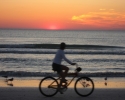 bicycling on beach with sunset